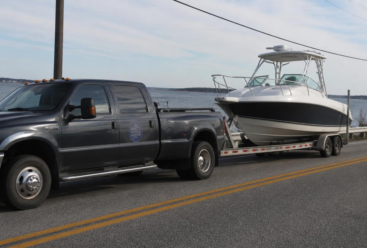 Dually pickup towing a powerboat on a hydraulic tandem-axle trailer on a coastal highway